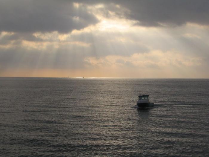 Sun rays on ocean and boat