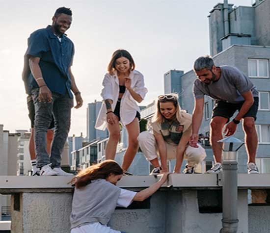 group of students on rooftop helping each other