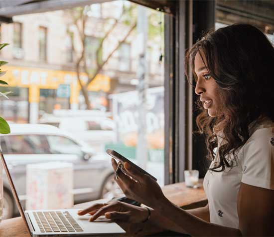 Women inside cafe with her laptop and cell phone