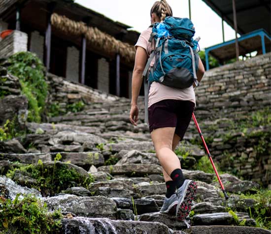 hiker climbing up stone waterway