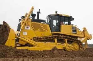 A large yellow bulldozer pushes dirt at a construction site, its wide blade and heavy tracks built for moving earth efficiently.