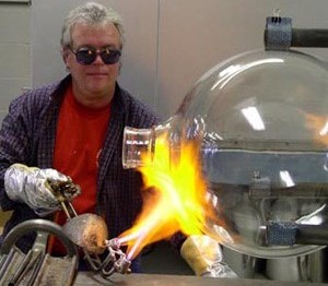 person wearing protective glasses and gloves blowing gas