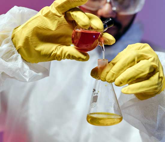 man mixing chemicals with proper gloves