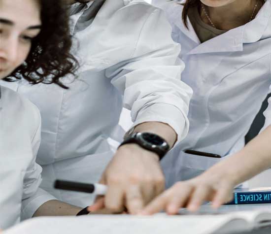 three lab workers looking over notes