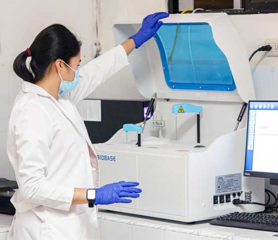 Lab worker looking inside machine