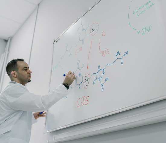 Lab assistant writing on white board